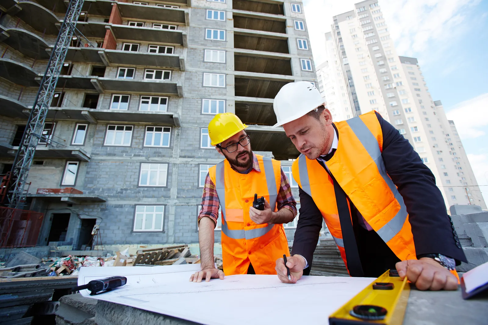 Engineers reviewing construction blueprints on site