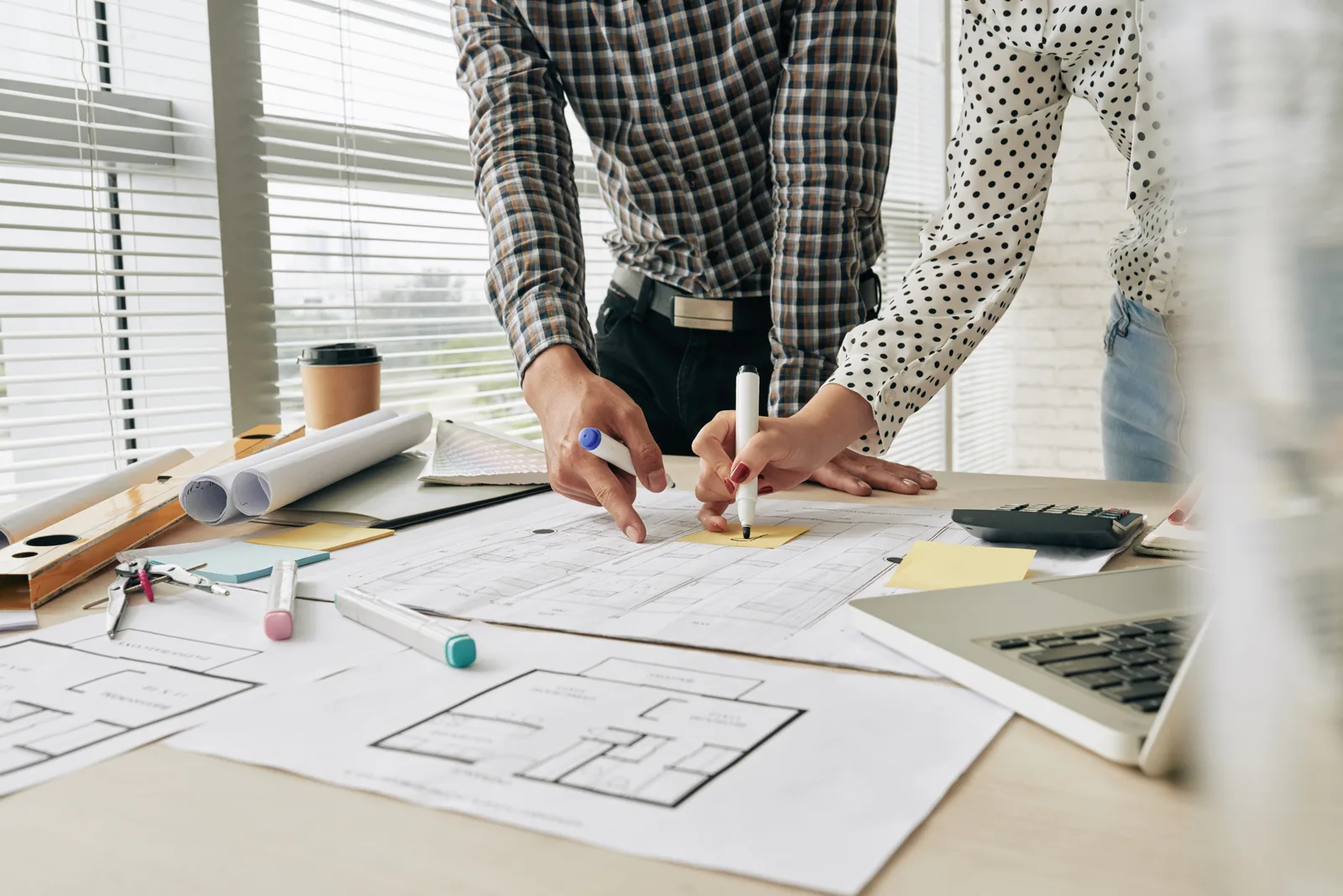 Tradespeople planning a job over a working blueprint